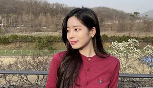 Dahyun Twice mengenakan cardigan merah yang dimasukan ke dalam celana denimnya. Gaya ini membuat Dahyun terlihat santai namun tetap rapi. Dok. Instagram @twicetagram