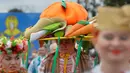 Seorang warga Belarusia memakai baju adat dan topi berhiaskan sayuran saat mengikuti Festival Dozynki di Minsk, Belarusia, Minggu (7/10). Festival ini merupakan bentuk syukur setelah hasil panen yang melimpah. (AP Photo/Sergei Grits)