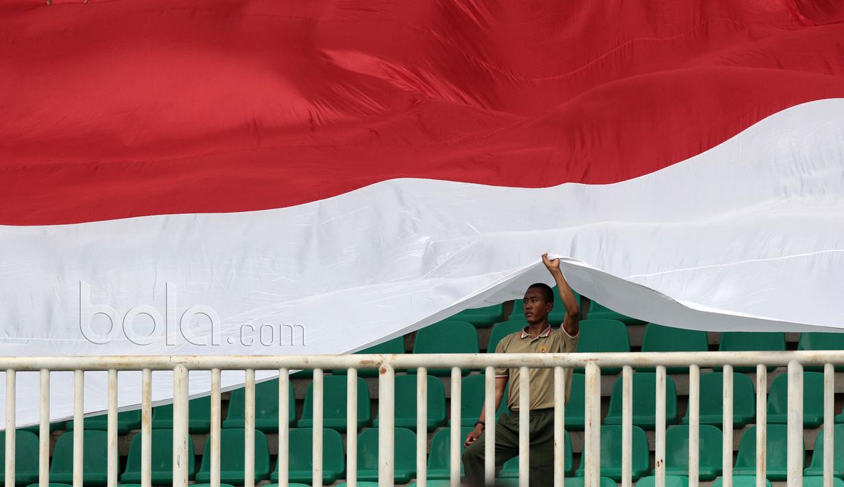 Pendukung PS TNI membentangkan bendera Merah-Putih saat timnya melawan Persiba Balikapapan pada Liga 1 2017 di Stadion Pakansari, Bogor, Jumat (5/5/2017). PS TNI dan Persiba bermain imbang 1-1.  (Bola.com/Nicklas Hanoatubun)