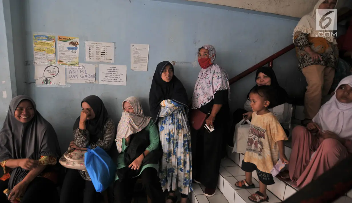 Warga antre membeli sembako murah dengan KJP di Pasar Blok G Tanah Abang, Jakarta, Selasa (11/12). Warga sangat antusias memanfaatkan KJP untuk membeli sembako murah karena harga yang lebih murah dari pasar. (Merdeka.com/Iqbal S. Nugroho)