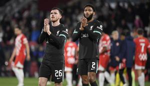 Bek Liverpool asal Skotlandia Andrew Robertson dan bek Liverpool asal Inggris Joe Gomez bertepuk tangan di akhir pertandingan sepak bola fase liga Liga Champions UEFA antara Girona FC dan Liverpool FC di stadion Montilivi di Girona pada 10 Desember 2024.Josep LAGO / AFP