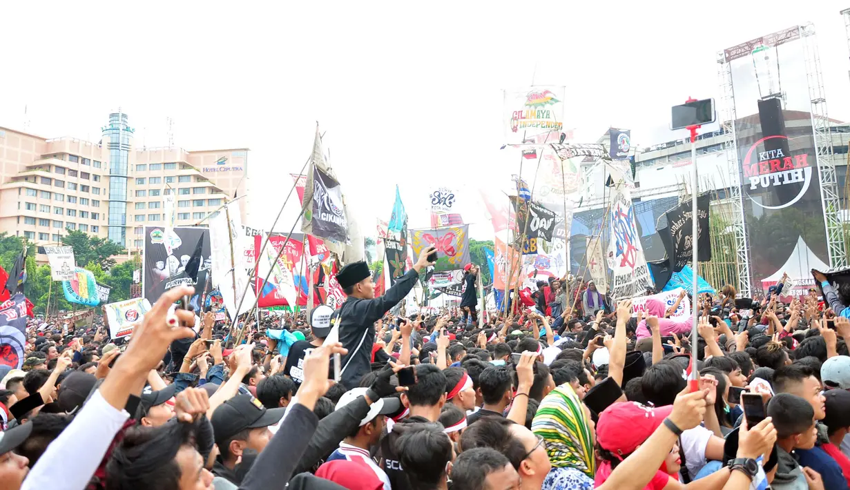 Para penonton menghadiri Apel Kebangsaan 'Kita Merah Putih' di lapangan Pancasila Simpang Lima Semarang, Minggu (17/3). Mengenakan pakaian dan ikat kepala serba merah putih, penonton berduyun-duyun ke lokasi acara. (Liputan6.com/Gholib)