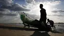 Nelayan Palestina, Mouad Abu Zeid dan teman-temannya membawa perahu dari botol plastik bekas di pantai Rafah, Jalur Gaza, 14 Agustus 2018. Setiap hari, Zeid menghasilkan uang sebanyak 5-11 dolar untuk 7 kg ikan yang berhasil ditangkap. (AFP/SAID KHATIB)