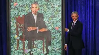 Presiden AS ke-44 Barack Obama menujuk lukisan dirinya saat upacara peresmian di Galeri Potret Nasional Smithsonian, Washington DC (12/2). Potret Presiden Obama ini dibuat oleh Kehinde Wiley. (Mark Wilson/Getty Images/AFP)