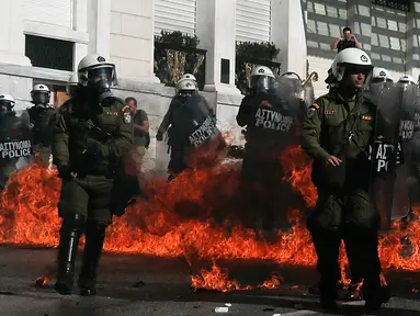 Sejumlah polisi anti huru-hara melawan aksi demonstran yang melemparkan bom api di Athena, Yunani, (12/11/2015). Para Demonstran memprotes langkah-langkah penghematan yang diminta oleh badan pinjaman internasional. (REUTERS/Alkis Konstantinidis)