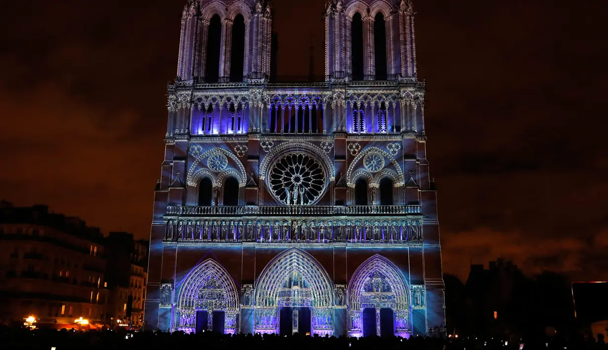 Pemandangan saat Gereja Katedral Notre-Dame de Paris dihiasi cahaya, Prancis (11/11). Pertunjukan cahaya ini dalam rangka peringatan Hari Gencatan Senjata yang menandai berakhirnya Perang Dunia I. (AFP Photo/Francois Guillot)