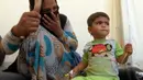 Seorang ibu melihat putrinya saat dirawat di kamp Hassan Sham U2, Irak (13/6). Menteri kesehatan Irak, Adila Hamoud mengatakan kepada The Associated Press di Baghdad 752 orang jatuh sakit dan setidaknya dua orang meninggal. (AP Photo/Balint Szlanko)
