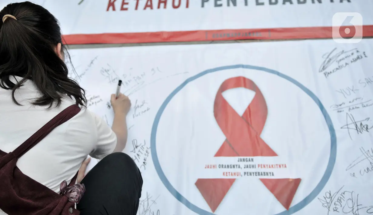Warga membubuhkan tanda tangan saat berpartisipasi dalam peringatan Hari AIDS Sedunia di Bundaran HI, Jakarta, Minggu (1/12/2019). Kegiatan ini bertujuan mengedukasi masyarakat tentang penyakit AIDS dan mengajak untuk peduli serta tidak menjauhkan penderita AIDS. (merdeka.com/Iqbal S. Nugroho)
