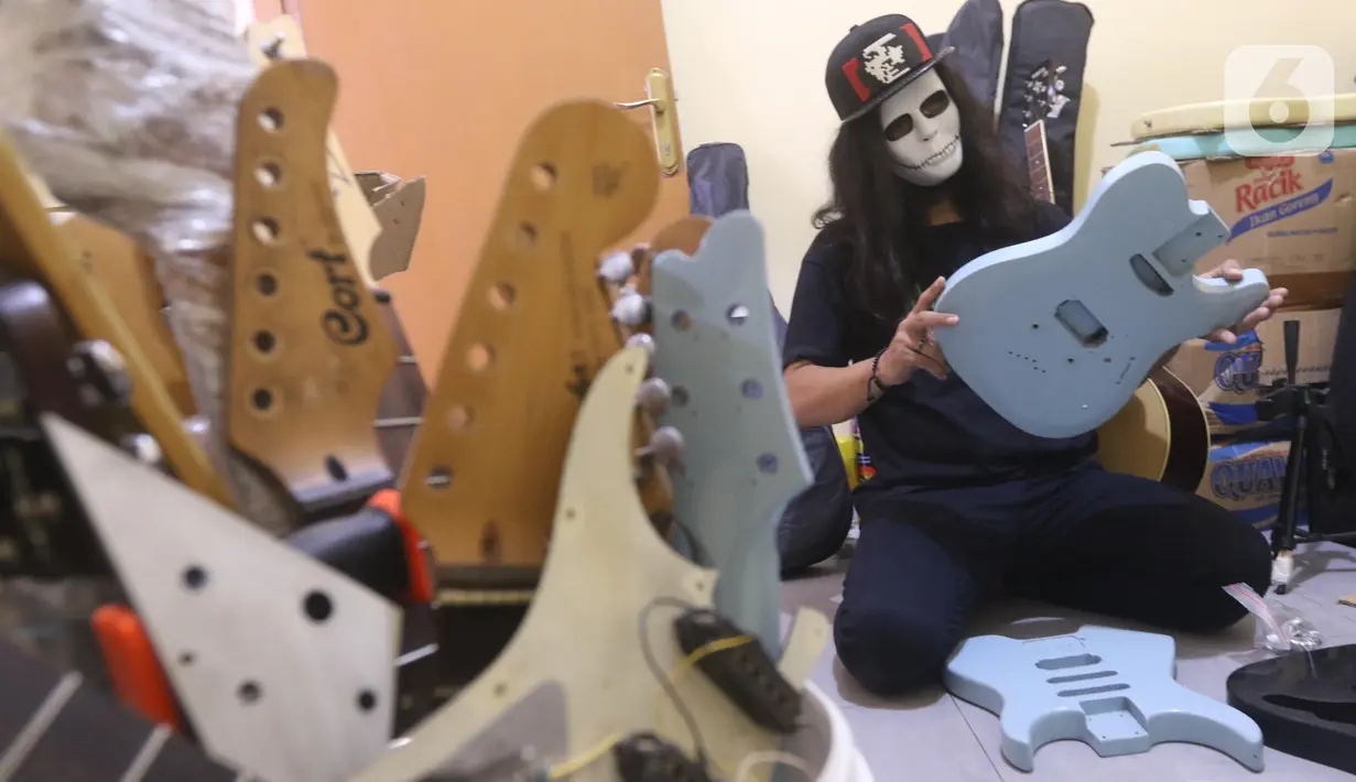 Pemilik showroom dan bengkel Gitar "music666", Ridwan dan Rudi mendemonstrasikan gitar yang akan dijual secara daring di Ciledug, Tangerang, Rabu (22/7/2020). Pemerintah menargetkan 10 juta usaha mikro kecil menengah (UMKM) pada tahun ini terhubung dengan platform digital (Liputan6.com/Angga Yuniar)