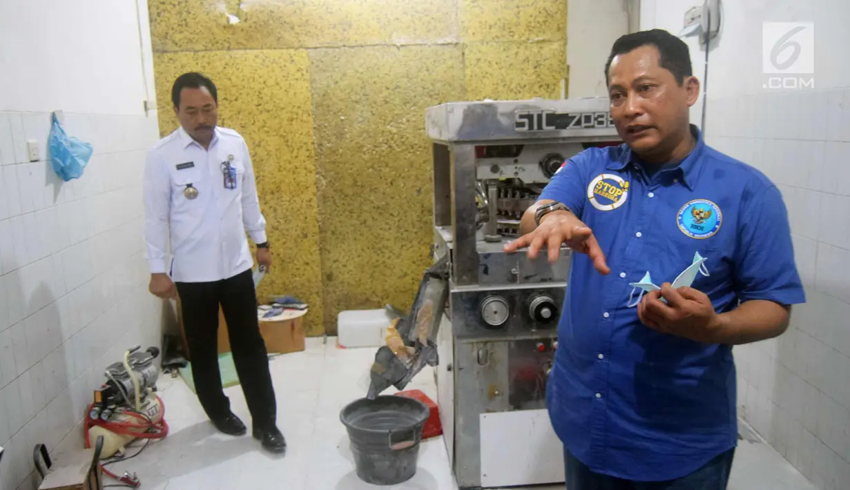 Kepala BNN Komjen Pol, Budi Waseso (kanan) menunjukkan barang bukti pencetak pil saat pengungkapan kasus pabrik pil PCC di Semarang, Jawa Tengah, Senin (4/12). Selain meringkus dua tersangka utama, BNN menyita 13 juta butir pil PCC. (Liputan6.com/Gholib)