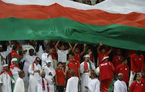 Para pendukung Oman membentangkan bendera raksasa saat Timnas Oman menghadapi Kirgistan pada laga ketiga Grup F Piala Asia 2023 di Abdullah bin Khalifa Stadium, Doha, Qatar, Kamis (25/1/2024). (AFP/Karim Jaafar)