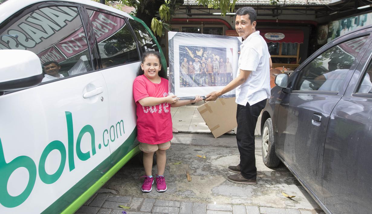 Usai menyantap kuliner sate padang bersama keluarga, pelatih Mitra Kukar, Jafri Sastra, menerima cinderamata dari kru Bola.com sebagai bentuk apresiasi terhadap dirinya. (Bola.com/Nick Hanoatubun)