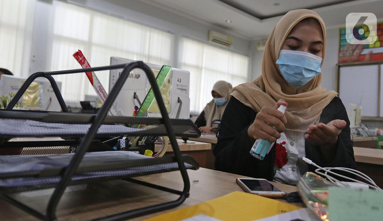 Murid sedang menggunakan hand sanitizer (pembersih tangan) sebelom melakukan kegiatan di SMKN 51, Jakarta, Rabu (7/4/2021). SMKN 51 melakukan uji coba masuk sekolah dan Uji Sertifikasi Kompetensi (USK) dengan protokol kesehatan yang ketat. (Liputan6.com/Herman Zakharia)