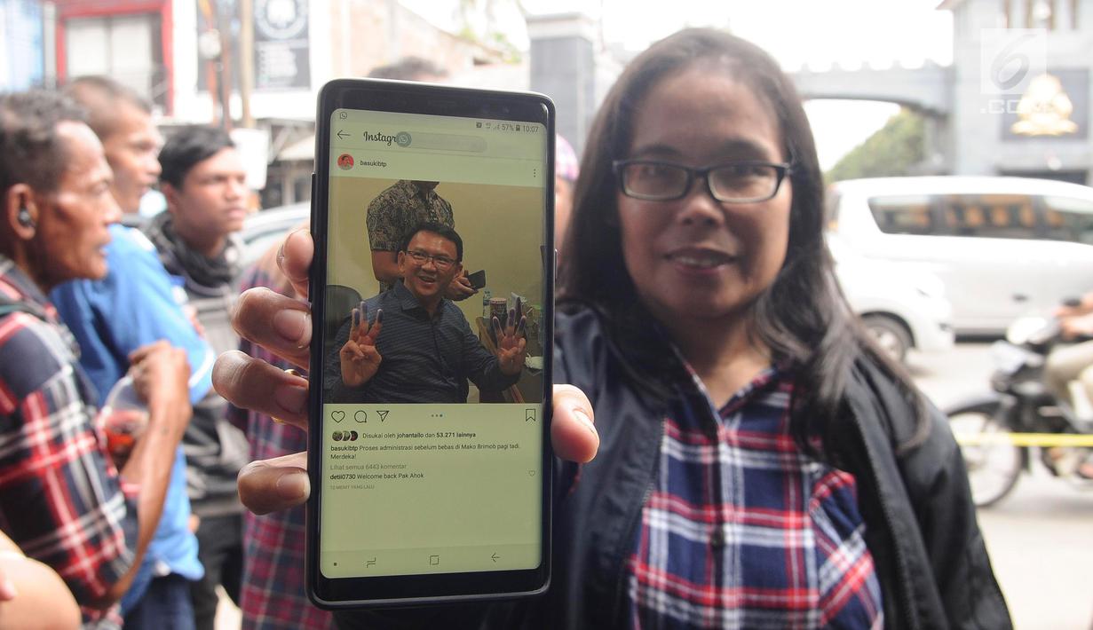 Pendukung menunjukkan foto Basuki Tjahaja Purnama atau Ahok di Mako Brimob, Kelapa Dua, Depok, Jawa Barat, Kamis (24/1). Belum dapat dipastikan kapan Ahok akan mulai beraktivitas dan bertemu dengan awak media. (Liputan6.com/Herman Zakharia)