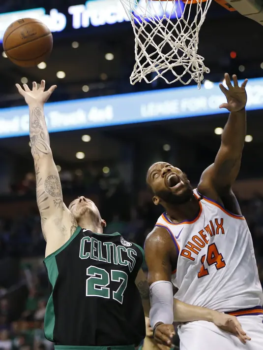 Pebasket Boston Celtics, Daniel Theis, berebut bola dengan pebasket Phoenix Suns, Greg Monroe, pada laga NBA di Stadion TD Garden, Boston Minggu (3/12/2017). Boston Celtics menang 116-111 atas Phoenix Suns. (AP/Michael Dwyer)