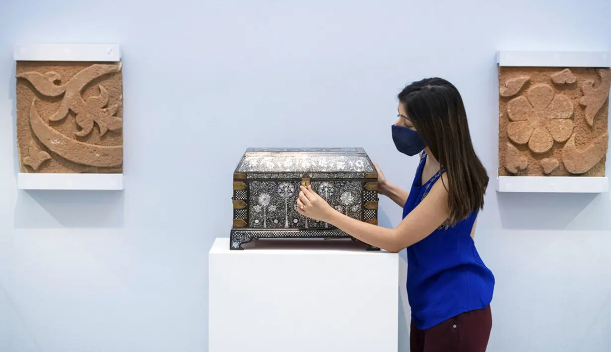 Karyawan rumah lelang Sotheby melihat peti mati bertatahkan mutiara yang diperkirakan bernilai 250.000-350.000 pound sterling sebagai bagian dari penjualan Arts of the Islamic World dan India pada 31 Maret di London, Inggris, Senin (29/3/2021). (Dominic Lipinski/PA via AP)