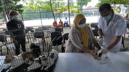 Dokter hewan dari  Suku Dinas Ketahanan Pangan Kelautan dan Pertanian Jakarta Selatan menyuntikkan vaksin antirabies kepada seekor kucing di Perumahan Bumi Karang Tengah, Jakarta Selatan, Selasa (21/9/2021). Kegiatan ini untuk mengantisipasi penyebaran penyakit rabies. (merdeka.com/Arie Basuki)