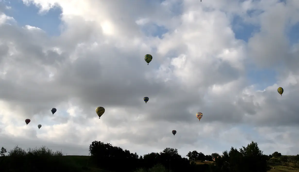 Sejumlah balon udara menghiasi langit selama festival internasional Sagrantino di kawasan Umbria, Italia, 22 Juli 2018. Puluhan balon udara berkompetisi menghadapi tantangan dalam festival yang memperebutkan piala perak tersebut. (AFP PHOTO/TIZIANA FABI)