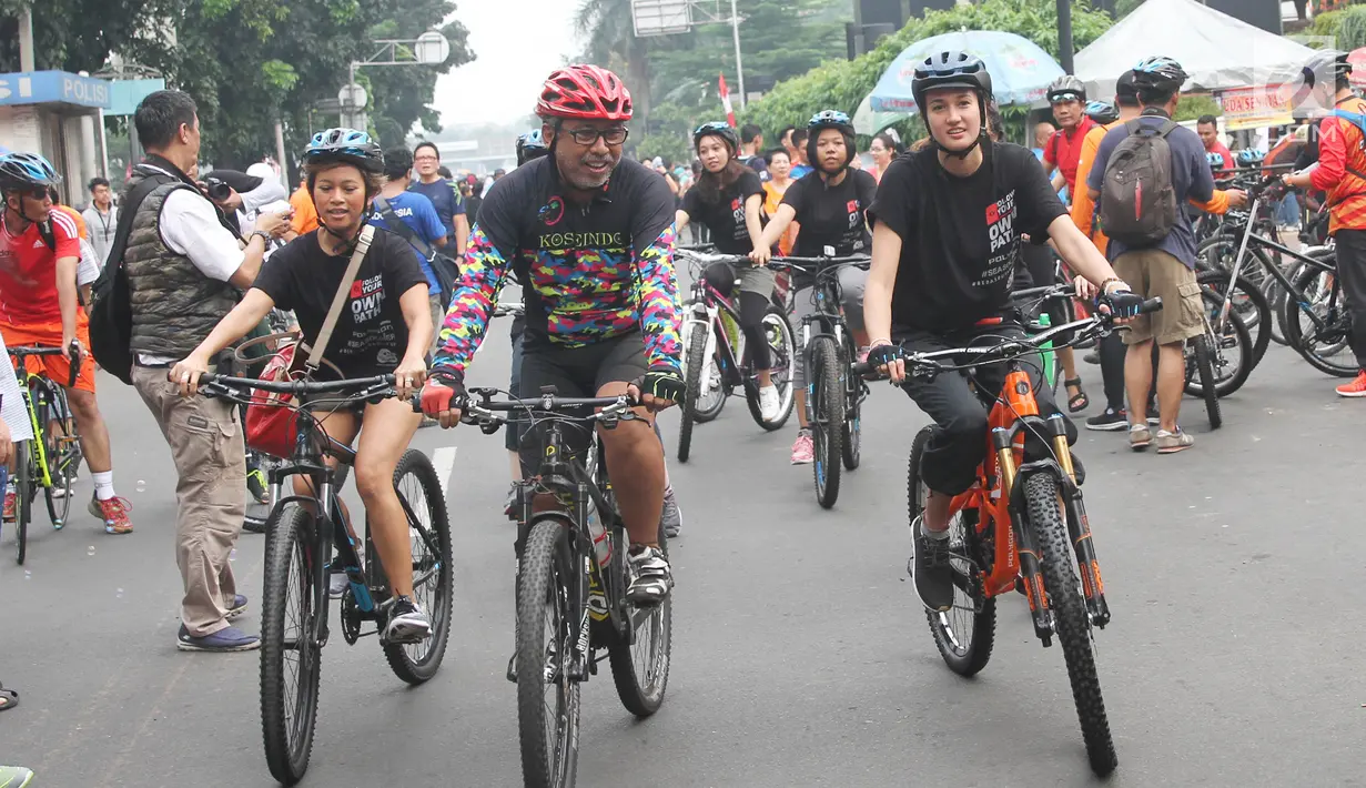 Artis peran Nadine Chandrawinata mengadakan kegiatan bersepeda sambil berkampanye gerakan #BebasButaHuruf di kawasan Sudirman, Jakarta, Minggu (13/). Nadine dan peserta bersepeda di kawasan Senayan sebanyak satu  putaran. (Liputan6.com/Herman Zakharia)