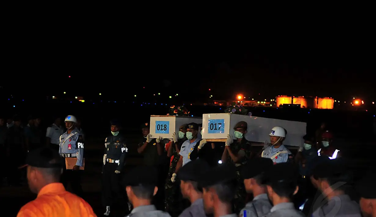 Anggota tim SAR gabungan menggotong 10 jenazah korban pesawat AirAsia QZ8501 di Lanud TNI AL Juanda, Surabaya, Jumat malam (2/1/2015). Kesepuluh jenazah tersebut langsung dibawa menuju RS Bhayangkara untuk menjalani otopsi. (Liputan6.com/Johan Tallo)