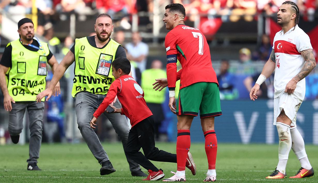 Petugas nampak kewalahan mengejar fans yang nekat menerobos lapangan. Total empat laga dihentikan lantaran fans nakal tersebut. (AFP/Frank Fife)