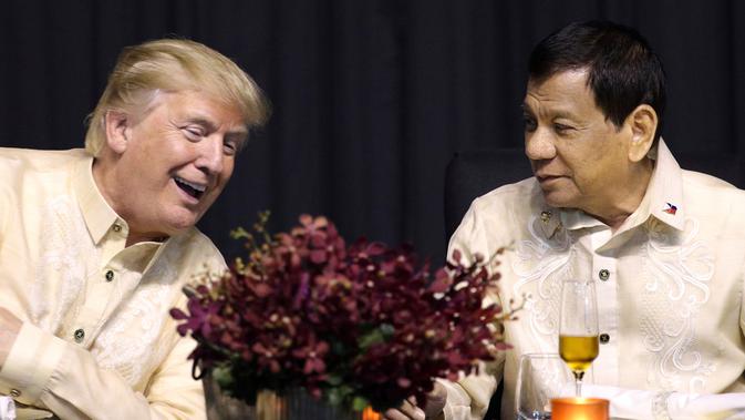 Presiden AS, Donald Trump berbincang dengan Presiden Filipina, Rodrigo Duterte dalam acara makan malam bersama konferensi ASEAN ke-31 di Manila, Minggu (12/11). Trump dan Duterte berbincang mengenai sejumlah isu. (AP Photo/Andrew Harnik)
