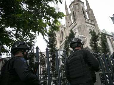 Personel kepolisian berjaga di depan Gereja Katedral, Jakarta, Kamis (1/4/2021). Sebanyak 150 personel gabungan TNI, Polri dan Satpol PP melakukan pengamanan jelang rangkaian perayaan Hari Paskah di gereja tersebut. (Liputan6.com/Faizal Fanani)