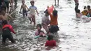 Sejumlah anak-anak bermain di genangan air akibat banjir rob di kawasan pintu masuk Pelabuhan Nizam Zachman, Muara Baru, Jakarta, Jumat (5/6/2020). Banjir rob di Pelabuhan Muara Baru tersebut terjadi akibat cuaca ekstrem serta pasang air laut. (Liputan6.com/Helmi Fithriansyah)