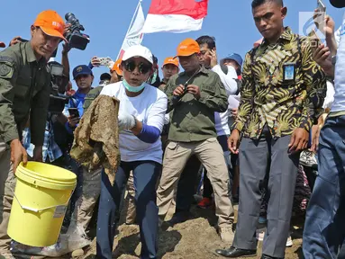 Menteri Kelautan dan Perikanan Susi Pudjiastuti (tengah) menunjukkan sampah yang ada di Pantai Timur Ancol, Jakarta, Minggu (18/8/2019). Dalam rangka HUT ke-74 RI, Pandu Laut Nusantara bersama KKP dan Yayasan Econusa akan menggelar Gerakan Menghadap Laut 2.0. (Liputan6.com/Herman Zakharia)