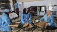 Para wanita membuat maftoul atau couscous di Khan Yunis, Jalur Gaza, Palestina, 10 Januari 2022. Maftoul adalah hidangan tradisional yang terbuat dari gandum bulgur kering. (SAID KHATIB/AFP)