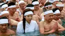 Peserta wanita diantara peserta lainnya ikut berendam di kolam air dingin di Teppozu Inari Shinto Shrine,Tokyo, Jepang (8/1). Tradisi ini diyakini dapat menjaga kesehatan tubuh dan pikiran mereka. (AP Photo/Shizuo Kambayashi)
