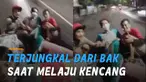 Pintu belakang bak tiba-tiba terbuka dan dua pemuda yang bersandar terjungkal.