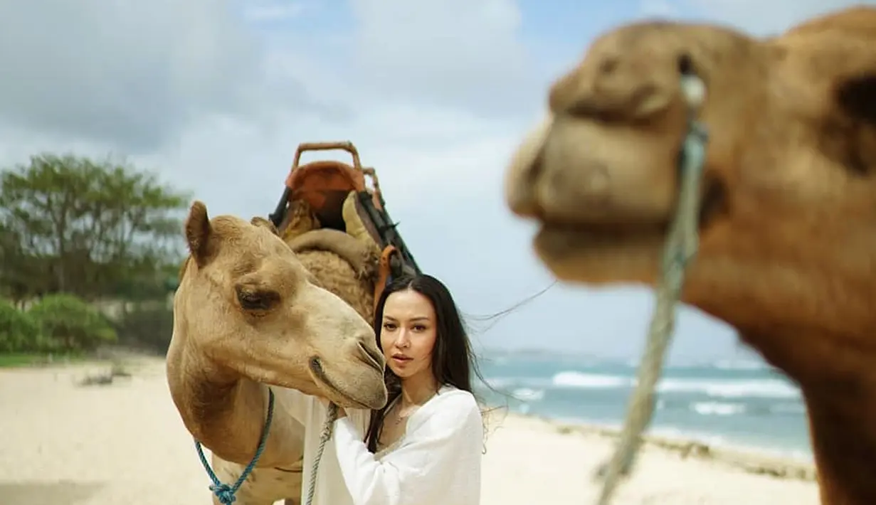Dalam liburannya ke Pulau Dewata, baru-baru ini ia pun unggah saat berada di Nusa Dua, Bali. Dalam liburannya di Nusa Dua, ia pun menikmati indahnya pantai dengan bersama dengan dua unta yang menemaninya. (Liputan6.com/IG/@karinadila8921)
