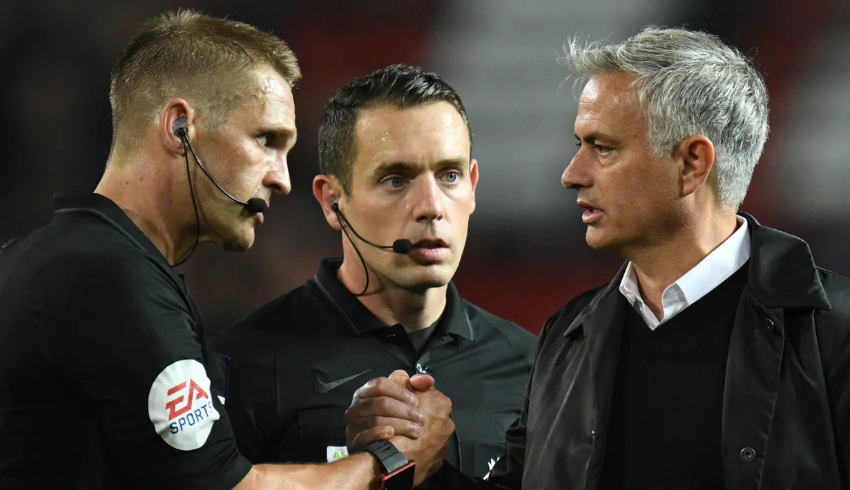 Pelatih Manchester United, Jose Mourinho berjabat tangan dengan wasit Craig Pawson usai pertandingan melawan Tottenham Hotspur pada lanjutan Liga Inggris di Old Trafford, (27/8). MU kalah telak atas tottenham 3-0. (AFP Photo/Oli Scarff)