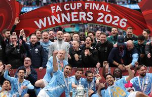 Para pemain dan staf Manchester City merayakan kemenangan bersama trofi di lapangan setelah pertandingan final Piala FA Inggris antara Chelsea melawan Manchester City di Stadion Wembley, London, pada 16 Mei 2026. Manchester City memenangkan pertandingan dengan skor 1-0. Gelar Piala FA ketiga pada era kepelatihan Pep Guardiola tersebut mengakhiri rentetan dua kekalahan beruntun City di partai final. (Adrian Dennis / AFP)