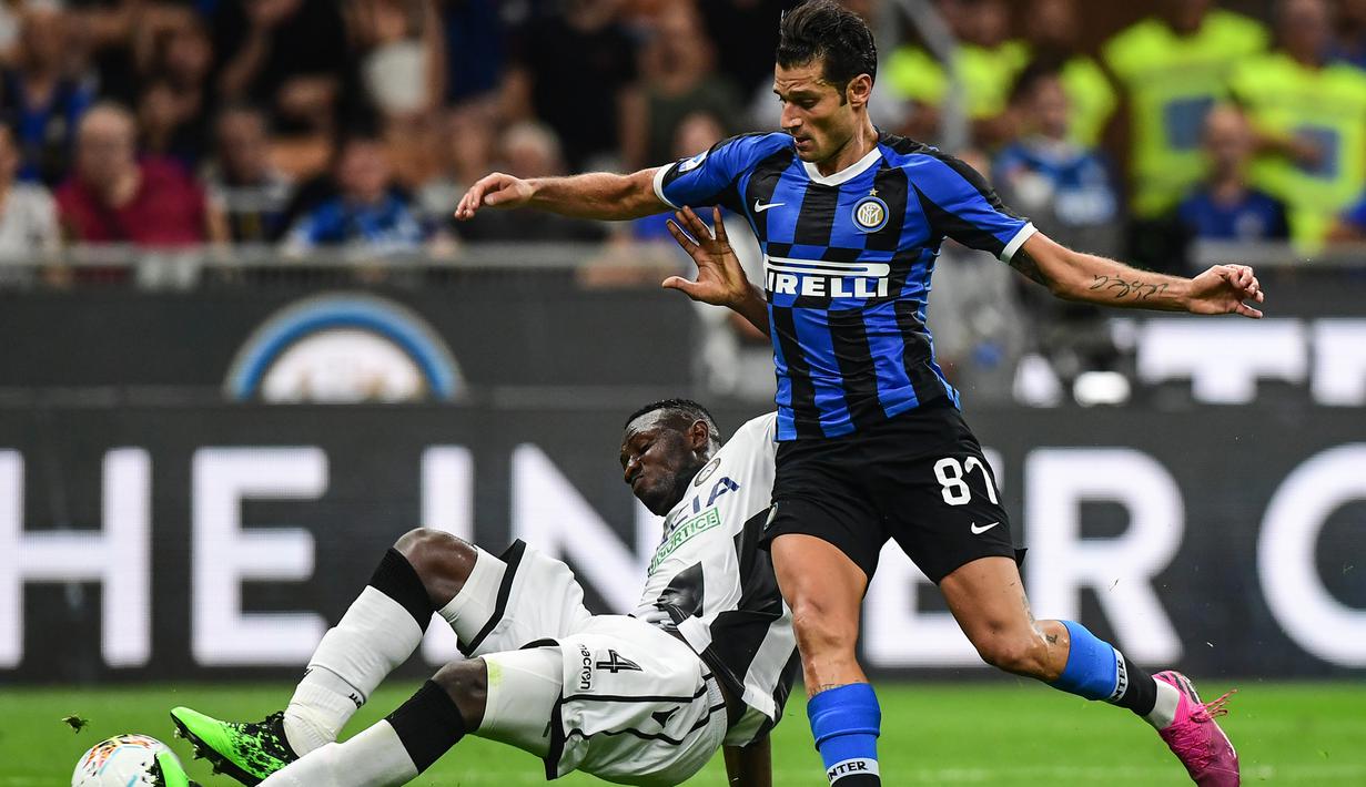 Gelandang Inter Milan, Antonio Candreva, menghindari tekel bek Udinese, Nicholas Opoku, pada laga Serie A 2019/20 di Stadion San Siro, Milan, Sabtu (14/9). Inter menang 1-0 atas Udinese. (AFP/Miguel Medina)