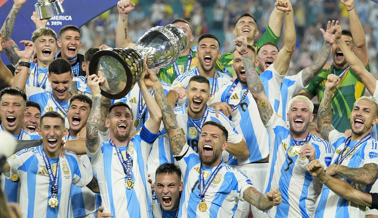 Selebrasi para pemain Timnas Argentina, Lionel Messi dkk merayakan gelar juara Copa America 2024 di atas podium usai mengalahkan Timnas Kolombia 1-0 pada laga final di Hard Rock Stadium, Florida, Amerika Serikat, Minggu (14/7/2024). (AP Photo/Rebecca Blackwell)
