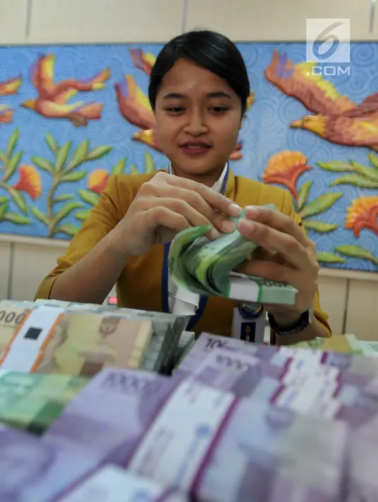 Teller menghitung uang pecahan kecil di kantor cabang Bank BJB di Melawai, Jakarta (7/6). Untuk mengantisipasi kebutuhan dan konsumsi saat berlebaran, pemerintah menyiapkan pasokan uang tunai tambahan tiap tahunnya. (Merdeka.com/Arie Basuki)