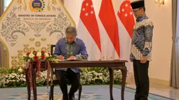 Dalam pernyataannya, Menteri Luar Negeri RI Sugiono menekankan pentingnya penguatan koordinasi antara Indonesia dan Singapura dalam menghadapi dinamika global yang berdampak pada ekonomi dan kawasan. Tampak dalam foto, Menteri Luar Negeri Indonesia Sugiono (kanan) menyaksikan Menteri Luar Negeri Singapura Vivian Balakrishnan mengisi buku tamu selama pertemuan mereka di Gedung Kementerian Luar Negeri, Jakarta pada Selasa 12 Mei 2026. (BAY ISMOYO/AFP)