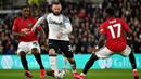 Pemain Derby County Wayne Rooney (tengah) mencoba melewati pemain Manchester United Odion Ighalo (kiri) dan Fred pada pertandingan putaran kelima Piala FA di Pride Park, Derby, Inggris, Kamis (5/3/2020). Manchester United menang dengan skor 3-0. (AP Photo/Rui Vieira)