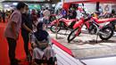 Pengunjung melihat koleksi sepeda motor yang dipamerkan dalam Indonesia International Motor Show (IIMS) 2023 di Jiexpo Kemayoran, Jakarta, Minggu (19/2/2023). Selain mobil, IIMS 2023 yang berlangsung hingga 26 Februari mengangkat tema "Bringing Opportunity for Otomotive Society Together" (BOOST) tersebut menghadirkan sekitar 40 merek produk sepeda motor dengan konsep terbaru. (merdeka.com/Iqbal S. Nugroho)