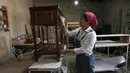 Tukang kayu Iran Sahar Biglari melukis produk saat bekerja di bengkelnya di Teheran, Iran, 12 Maret 2023. Semakin banyak perempuan Iran berjuang untuk mengatasi hambatan gender. (AP Photo/Vahid Salemi)