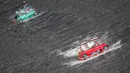 Sebuah mobil amphibi berwarna merah terlihat memimpin di depan dalam acara reli "Amphib 2014" yang berlangsung di  sungai Mosel, Jerman, Minggu (3/8/2014)  (AFP PHOTO/Fredrik VON Erichse)
