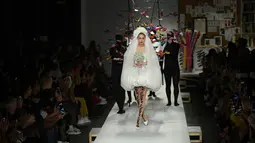 Gigi Hadid berjalan di runway mengenakan gaun rumah mode Moschino untuk koleksi SS19 selama gelaran fashion week di Milan, Italia, Kamis (20/9). Bagian kaki jenjang Gigi Hadid ditopang sepatu model pointed heels silver metalik. (AFP/Marco BERTORELLO)