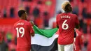 Dua pemain muslim Manchester United, Paul Pogba dan Amad Diallo, membentangkan bendera Palestina di markas Manchester United, yaitu Stadion Old Trafford. (Foto: AFP/Pool/Paul Ellis)