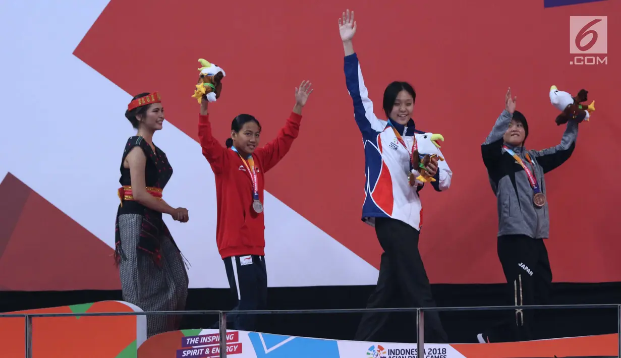 Atlet para renang, Syuci Indriani (kedua kiri) usai laga final 100 meter kupu kupu putri S14 Asian Para Games 2018 di Stadion Akuatik Kompleks GBK, Rabu (10/10). Syuci meraih perak dengan waktu 1 menit 11,08 detik. (Liputan6.com/Helmi Fithriansyah)