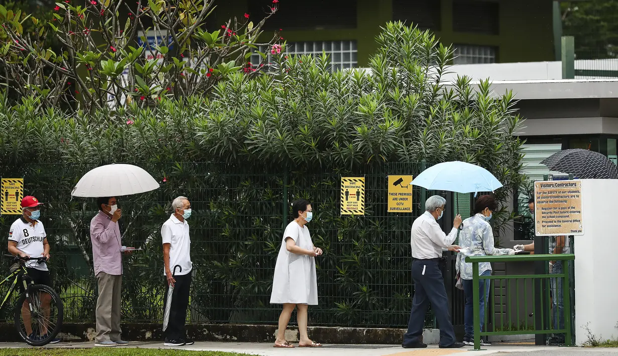 Para pemilih mengenakan masker dan menerapkan jaga jarak aman saat akan memberikan suara dalam pemilu di TPS Sekolah Dasar Alexandra, Singapura, Jumat (10/7/2020). Pemilu di tengah pandemi COVID-19, warga Singapura memberikan suaranya dengan mengenakan masker dan sarung tangan plastik. (AP Photo)