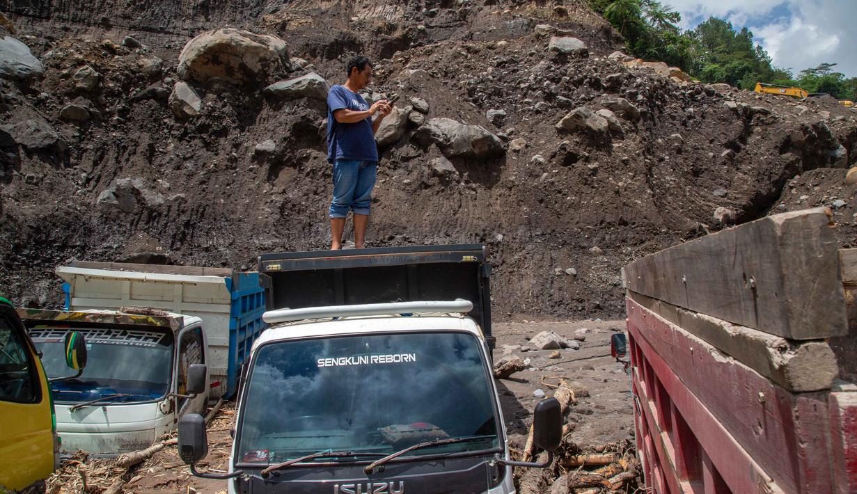 Sejumlah kendaraan berat yang berada di lokasi terdampak arus banjir lahar dingin tersebut. Tampak dalam foto, warga berusaha mengambil bagian-bagian truk yang terkubur di pasir setelah longsor lumpur akibat hujan dari Gunung Merapi di Sungai Senowo, Magelang, Jawa Tengah pada Rabu 4 Maret 2026. (Devi Rahman/AFP)