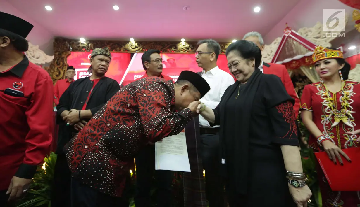Calon gubernur kalimantan Timur Irjen Safaruddin mencium tangan Ketum PDIP Megawati Soekarnoputri usai menerima surat mandat saat pengumuman cagub-cawagub PDIP di kantor DPP PDIP Lenteng Agung, Jakarta, Minggu (7/1). (Liputan6.com/Faizal Fanani)