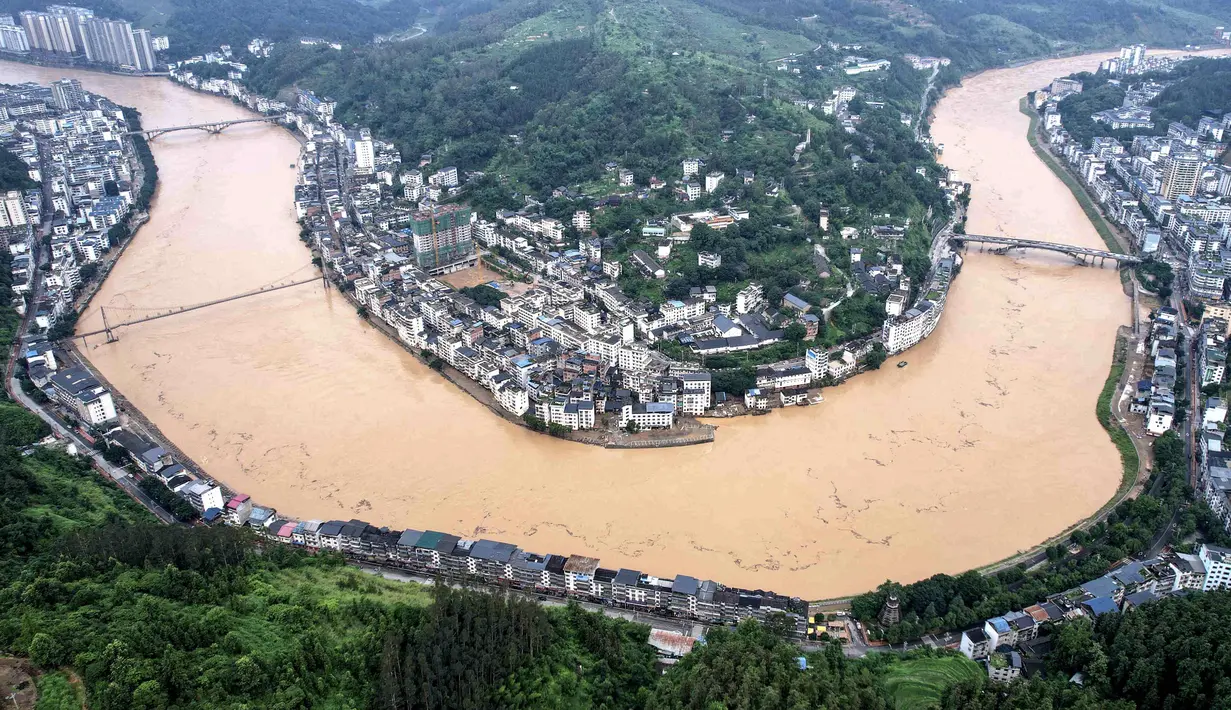 Dilaporkan enam orang tewas akibat banjir yang menggenangi provinsi Guizhou, barat daya China, Kamis (26/6/2025). Tampak dalam foto pemandangan udara gedung-gedung dan jalan-jalan yang terendam banjir di Congjiang, provinsi Guizhou barat daya China pada 25 Juni 2025. (AFP/China OUT)